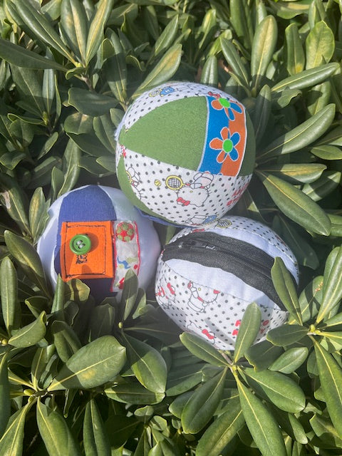 Pelota sensorial Tinkero hecha a mano con bolsillos y botones
