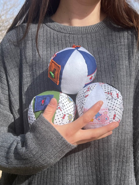 Pelota sensorial Tinkero hecha a mano con bolsillos y botones